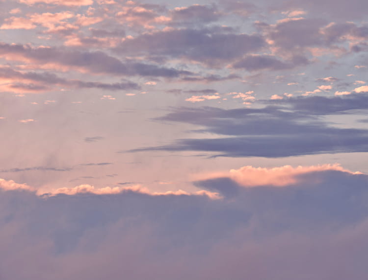 たなびく雲の群れを夕暮れが紫に染める